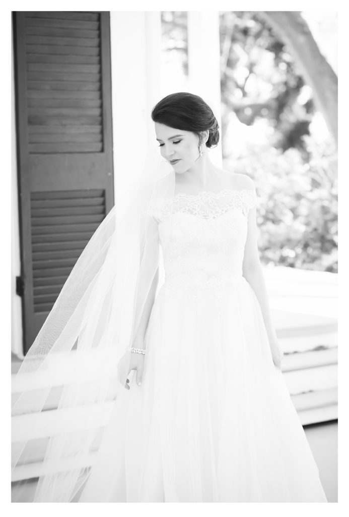 Black and white photo of bride glancing over shoulder during bridal session at the old place in gautier ms