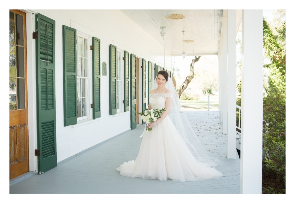 Bride at the old place in gautier on porch for bridal portrait holding bouquet