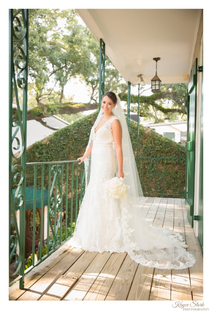 Bride in Lace Wedding Dress and holding bouquet by After the Proposal with Bridal Portraits by Kayce Stork Photography at Mary Mahoney's in Biloxi