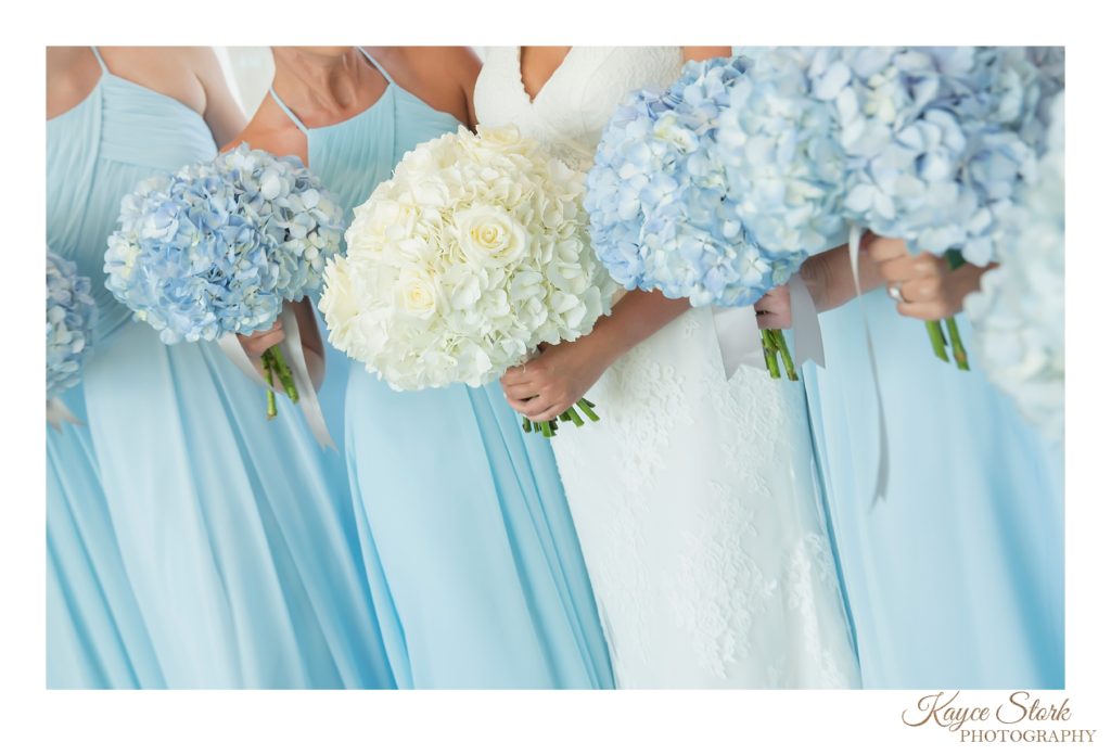 Bride holding white hydrangea bouquet and bridesmaids with blue hydrangeas designed by After the Proposal