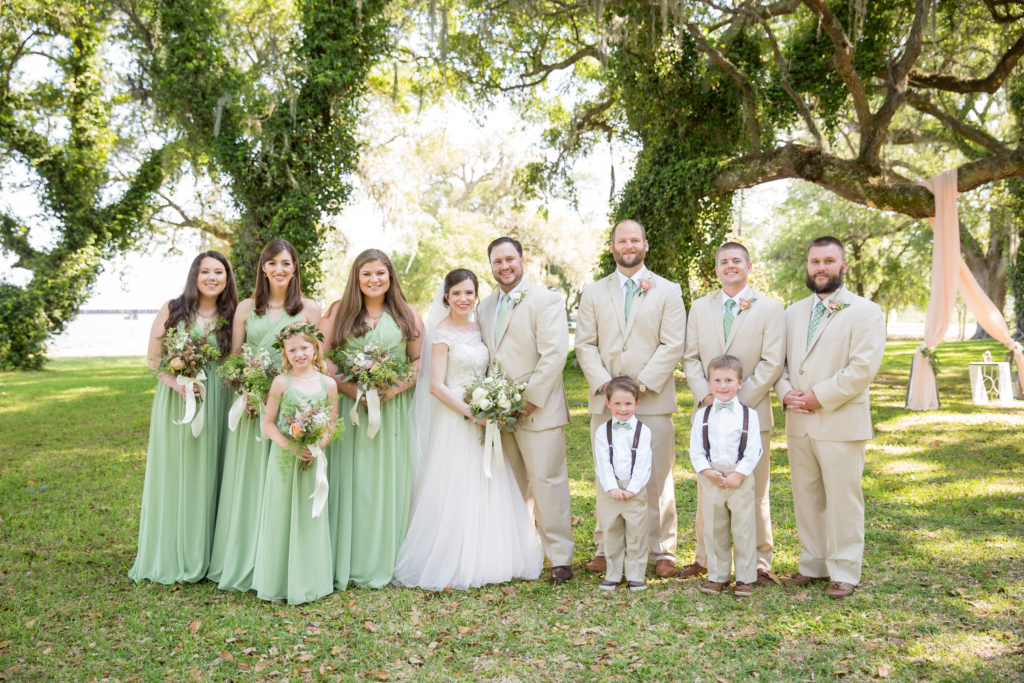 Bride and Groom with bridesmaids in light green dresses and men in khaki suits at the The Old Place in Gautier