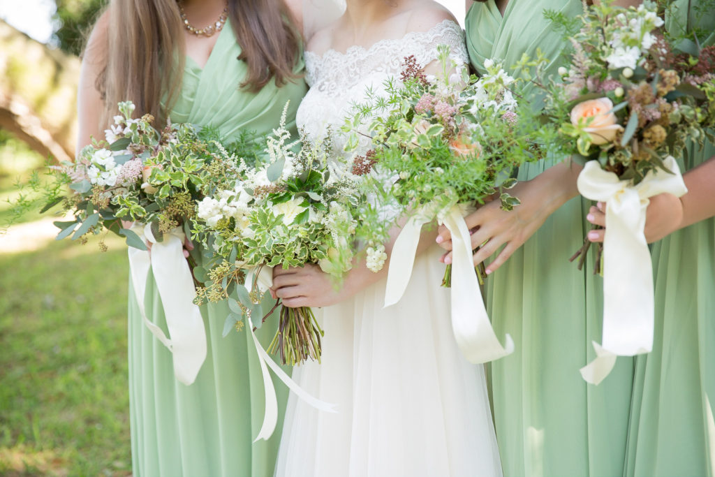 Bride and Bridesmaids holding bouquets by After the Proposal on wedding day at the old place in gautier ms 