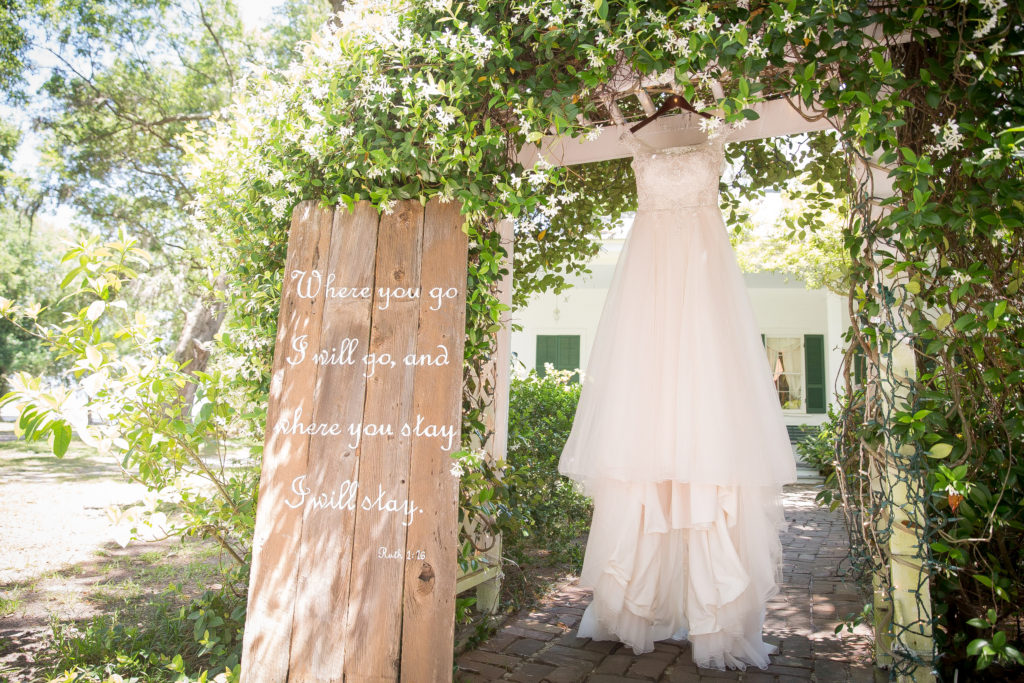 Brides dress designed by Sincerity Bridal from Bilss Bridal in Fairhope hanging on arch at the old place in Gautier MS for Wedding Day